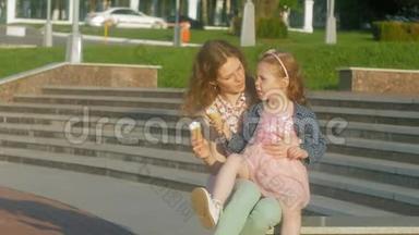 妈妈和女儿在公园里吃冰淇淋。 母亲和孩子。 <strong>轻松愉快的</strong>家庭